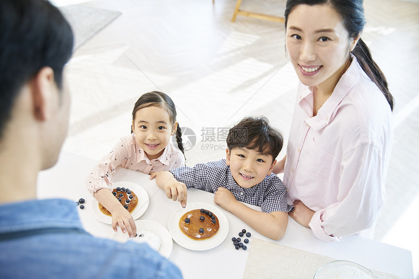 在厨房里跟父母一起做甜品的小朋友图片