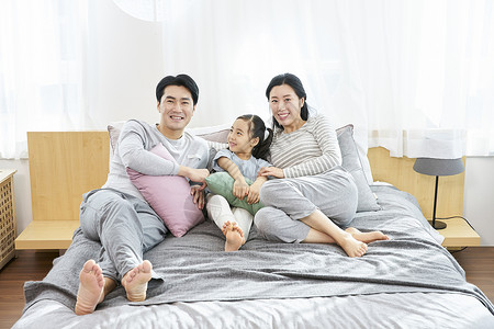 一家人开心的在床上聊天图片