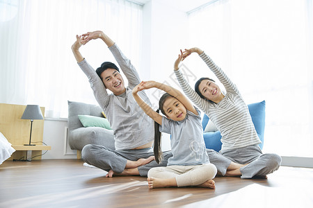 客厅可爱幸福的一家人做瑜伽图片