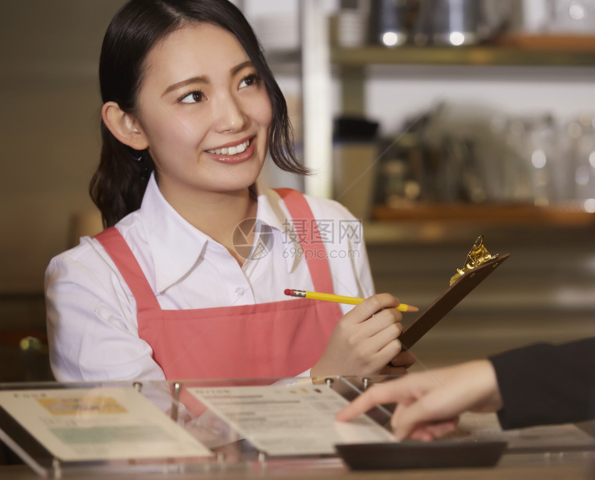 收款台解释日本人在一家咖啡馆工作的妇女图片