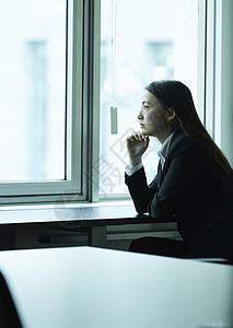 默默地办公楼打破在窗户旁商业女人背景