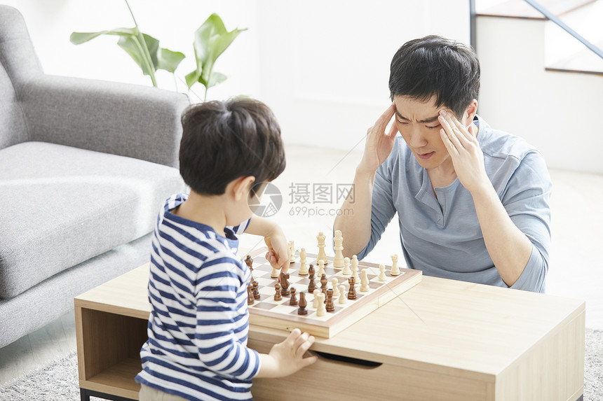 客厅里看着棋盘苦恼的父亲图片