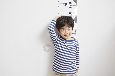 测量身高的小男孩背景图片
