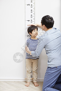 测量孩子身高的父亲图片