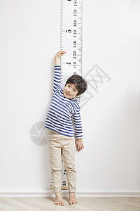 孩子性格孤僻踮脚测量身高的小男孩背景