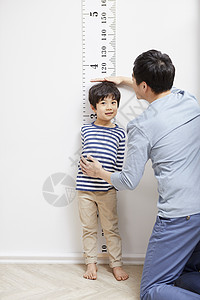 父亲给儿子测量身高图片