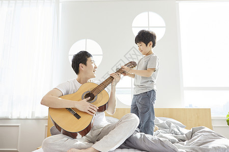 床上弹奏吉他的父亲图片