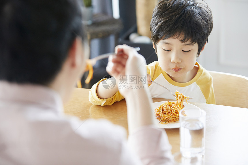 父子二人在餐桌上吃意面图片