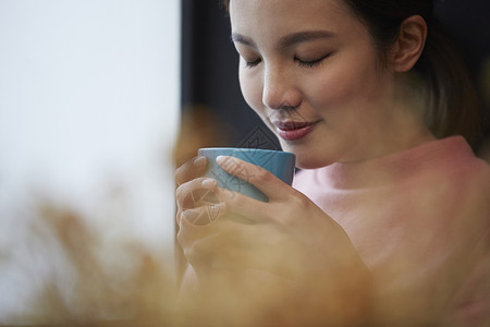 捧着水杯的青年女性图片