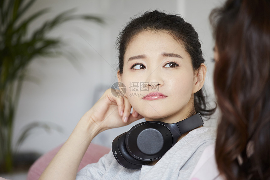 脖子上戴着耳机的青年女子图片