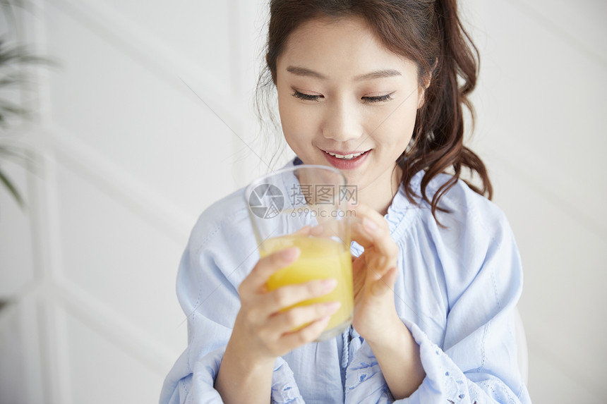 生活的年轻女人喝着果汁图片