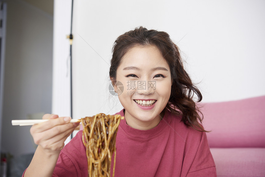 快乐生活的年轻女人吃美食图片