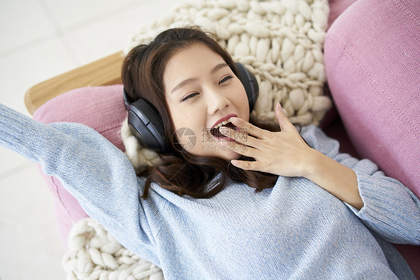 头戴式耳机听音乐的年轻女人图片