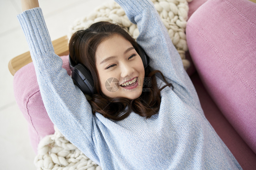 头戴式耳机听音乐的年轻女人图片