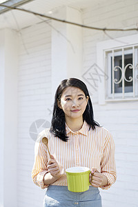 户外拿着杯子木勺微笑的少女图片