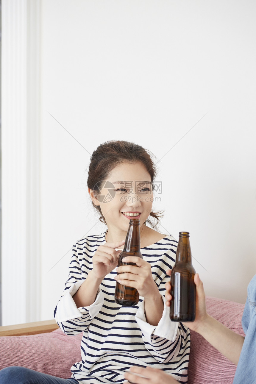 拿着酒瓶微笑的年轻女子图片