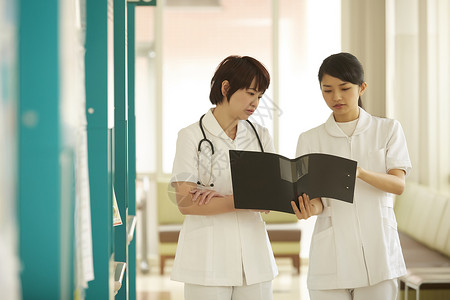 在医院病房走廊上的女护士交流工作背景图片