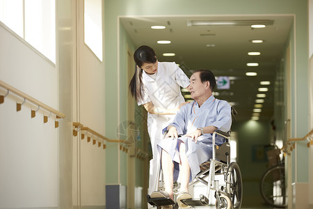 护士关切问候坐轮椅的老人高清图片