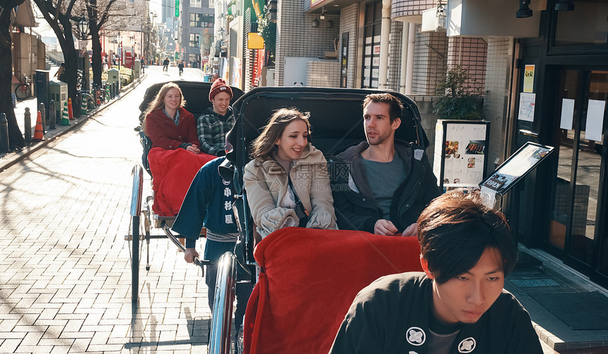 在东京旅游的外国游客乘坐人力车图片