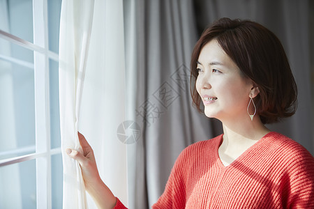 30多岁假期日本人站立在窗口的妇女图片