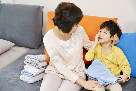 小男孩和奶奶在客厅叠衣服背景图片