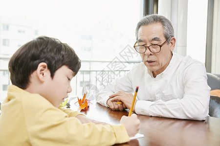 爷爷看着小男孩写字图片