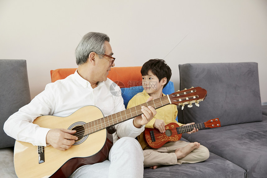 爷爷和小男孩在客厅弹奏音乐图片