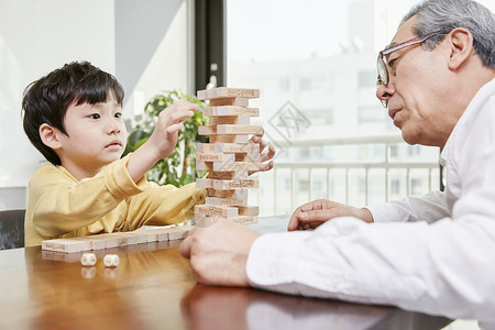 掷骰子爷爷和孙子一起拼积木背景