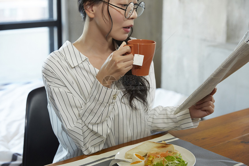 喝咖啡看报纸的女青年图片