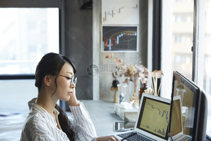 年轻女子看着电脑上的交易信息图片