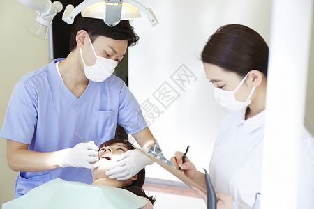 牙科医生给病患做牙齿治疗图片
