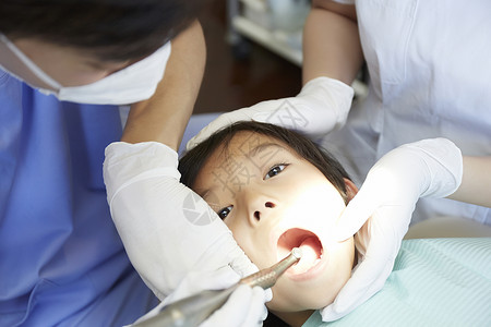 牙科医生给小男孩治疗牙齿图片