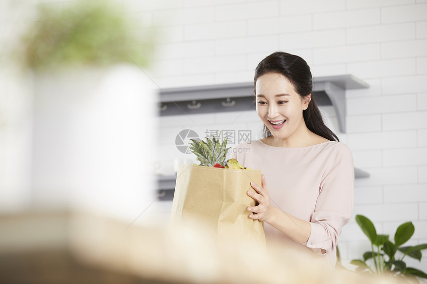 看着一大袋蔬果惊讶的女青年图片