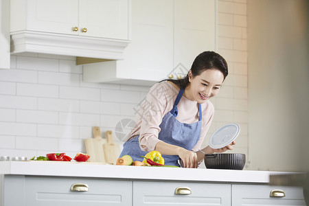 厨房里烹调食物的年轻女子图片