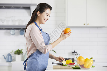 看着橙子微笑的成年女子图片