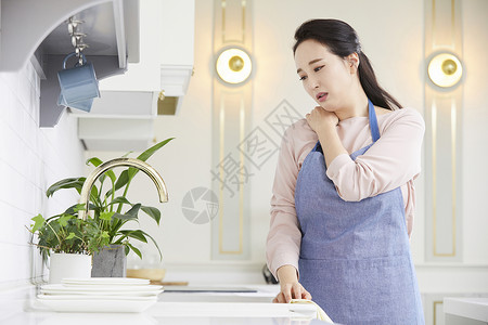 按摩肩颈的成年女子图片