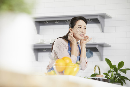 双手摸着耳垂被躺倒的成年女子图片