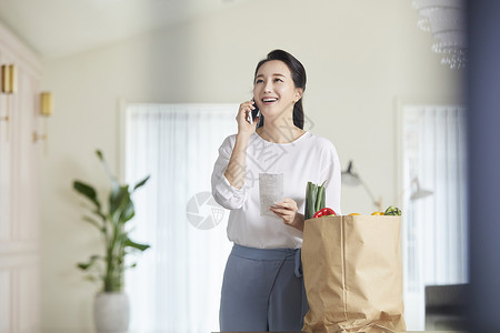 拿着小票接电话的成年女子背景图片