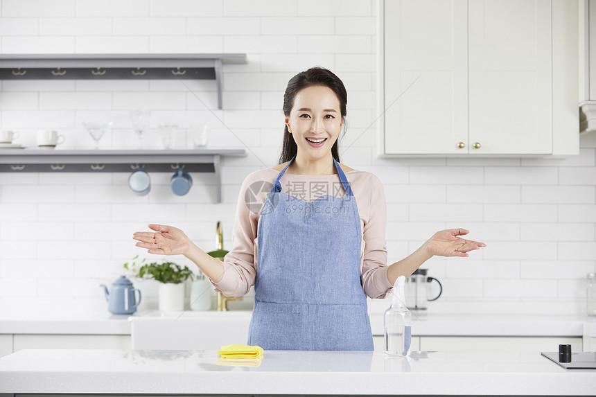 厨房里摊开手微笑的成年女性图片