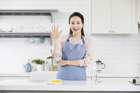 厨房里举手微笑的青年女性图片