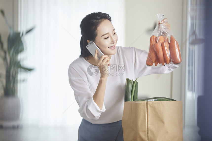 打电话拿着胡萝卜微笑的女青年图片