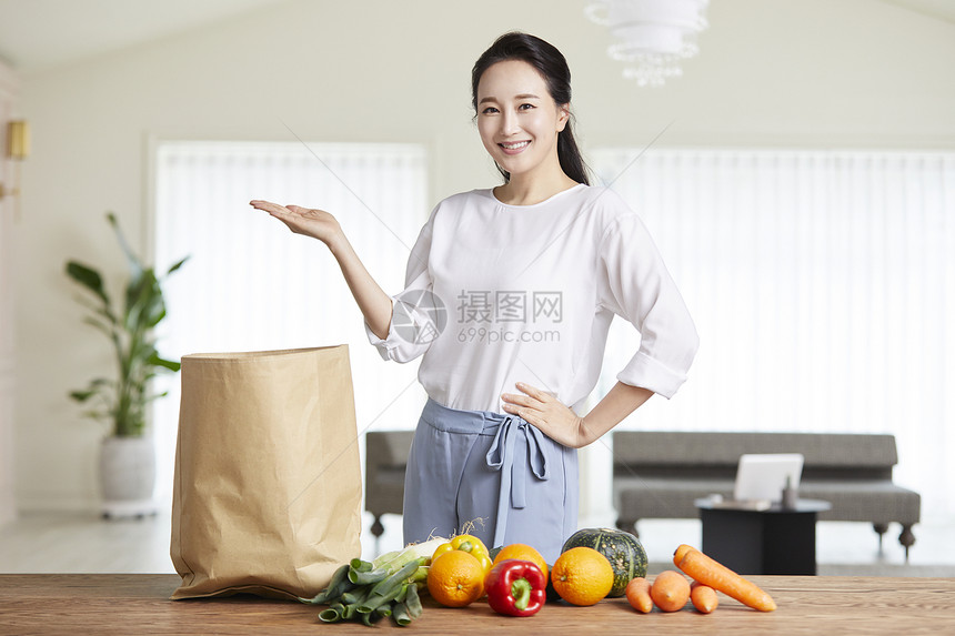 举手展示微笑的年轻女子图片