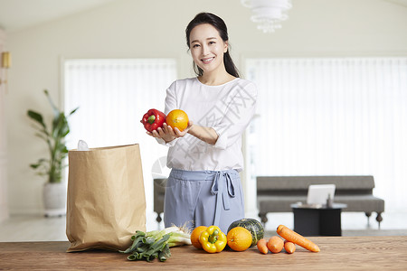 青年女子捧着蔬果微笑图片