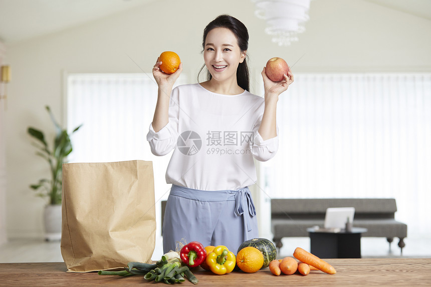 拿着水果开心的成年女子图片