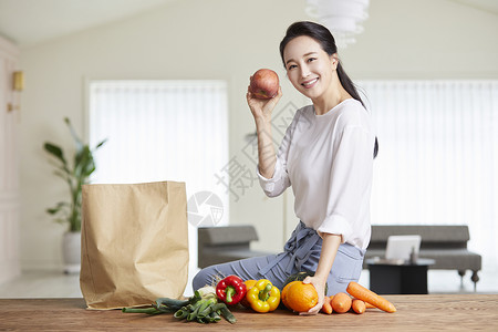 拿着苹果微笑的青年女性图片