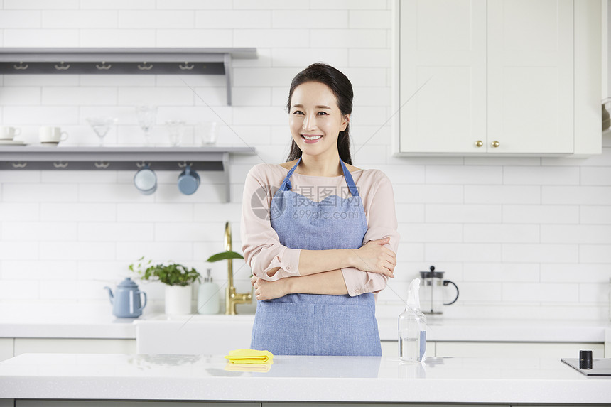 厨房里穿着围裙微笑的成年女子图片