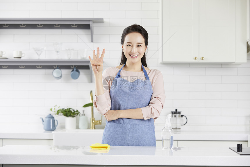 青年女子穿着围裙比手势微笑图片