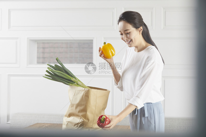 手上拿着蔬菜微笑的女青年图片