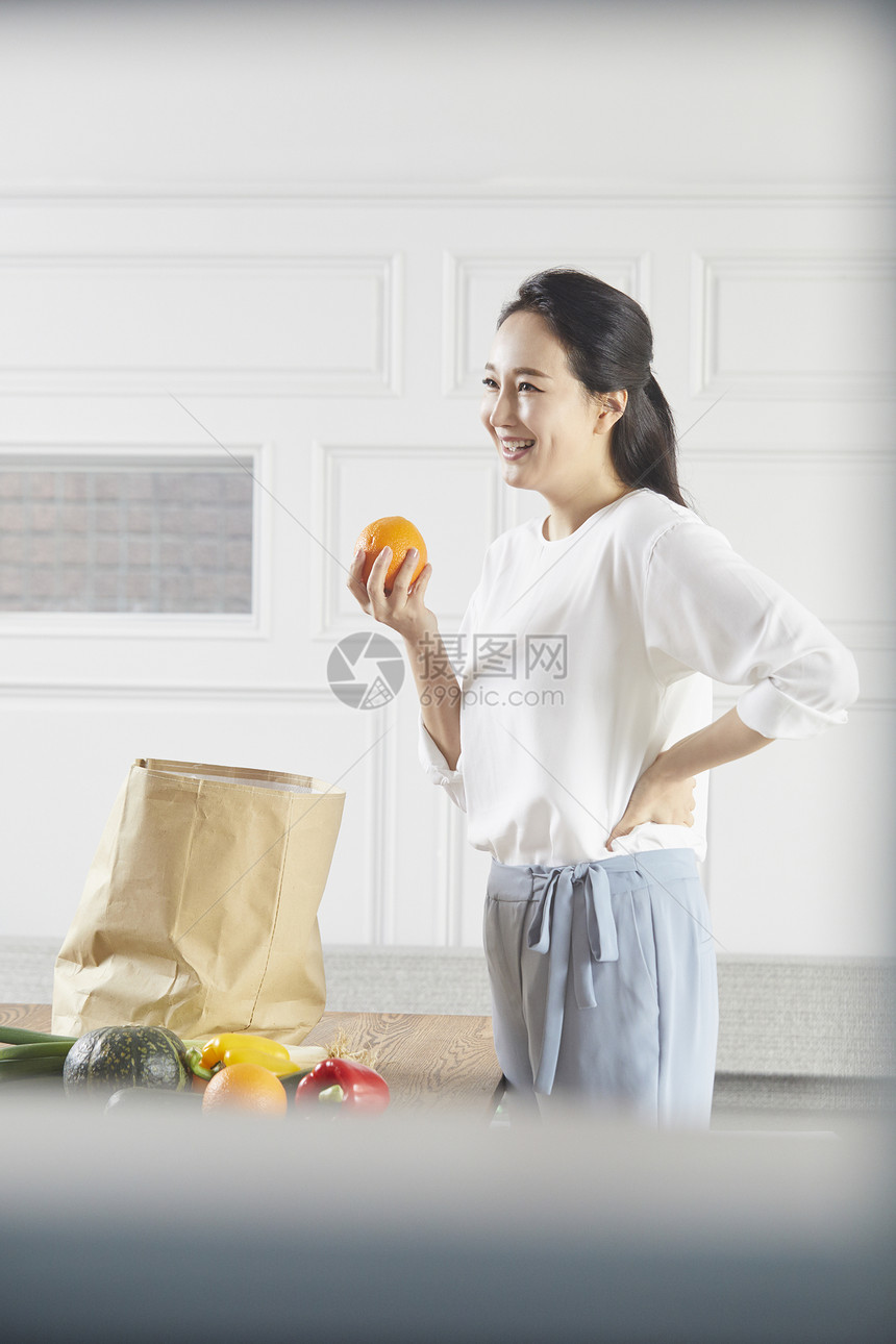 拿着橙子微笑的女性图片