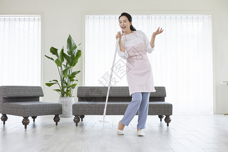 拿着拖把唱歌的青年女子图片